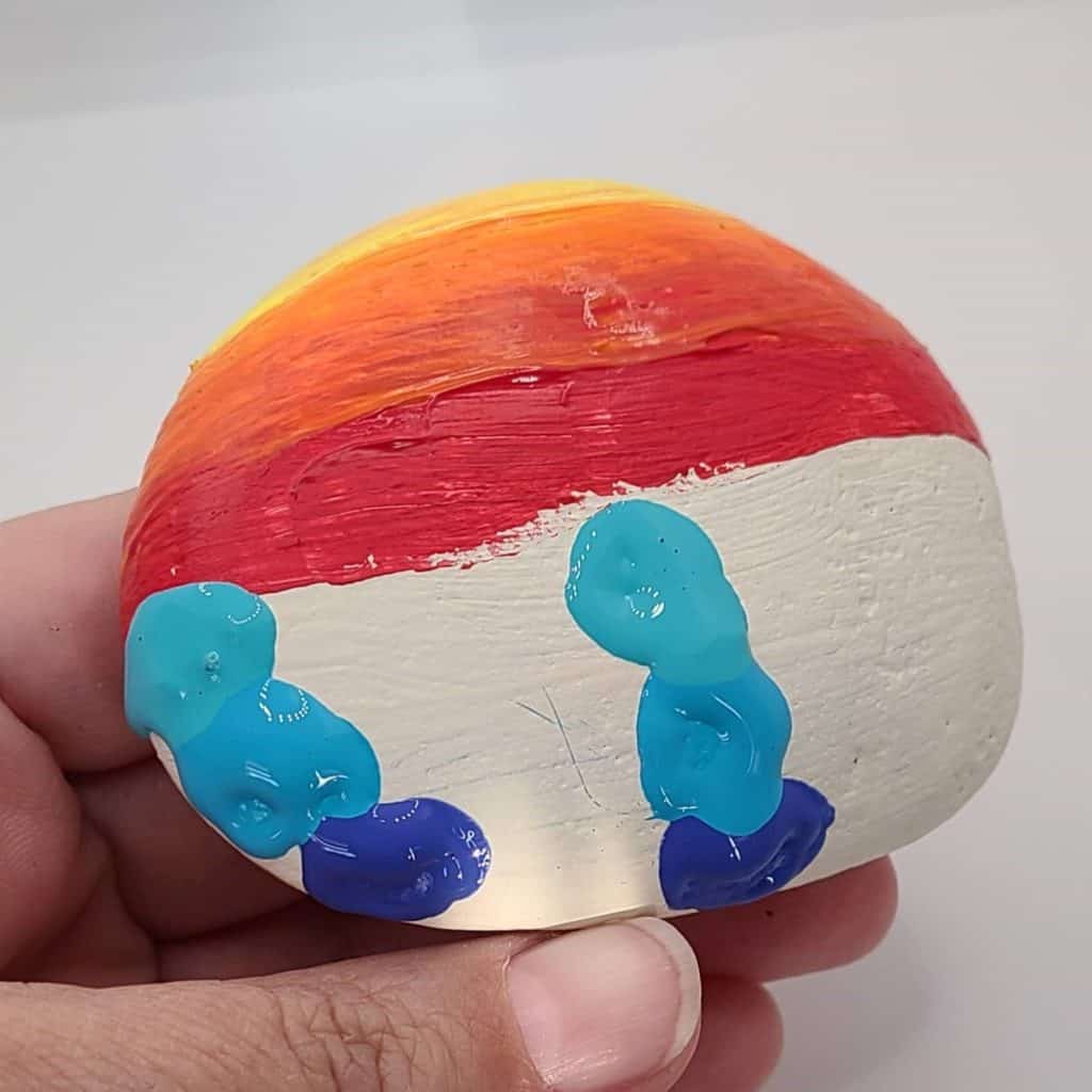 sunset painted rocks sailboat applying paint