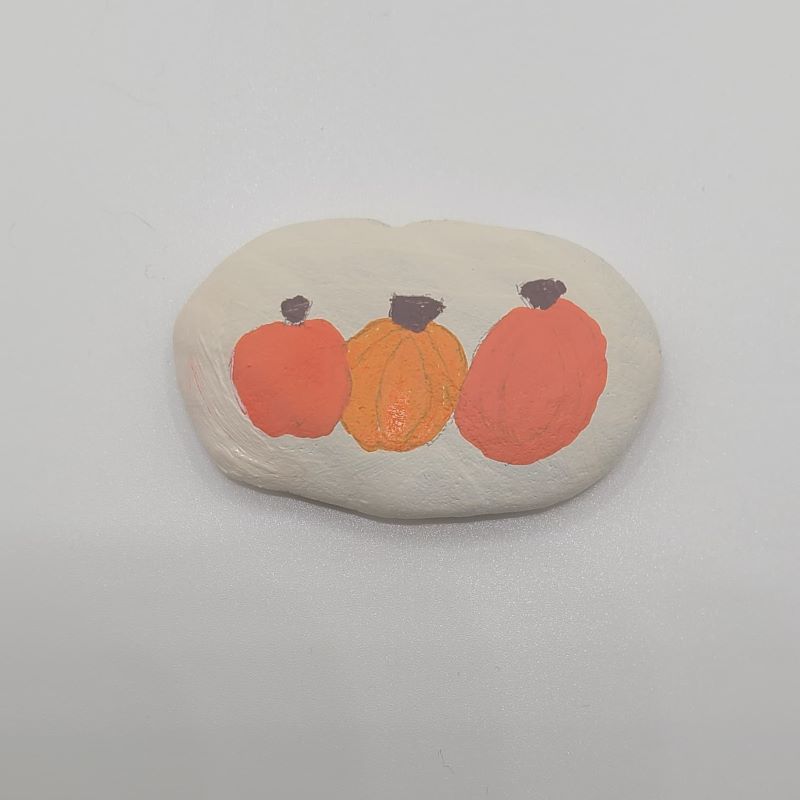 Painting pumpkins on a rock 1