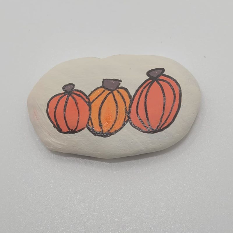 Painting pumpkins on a rock 2