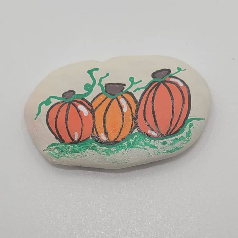 Painting pumpkins on a rock final